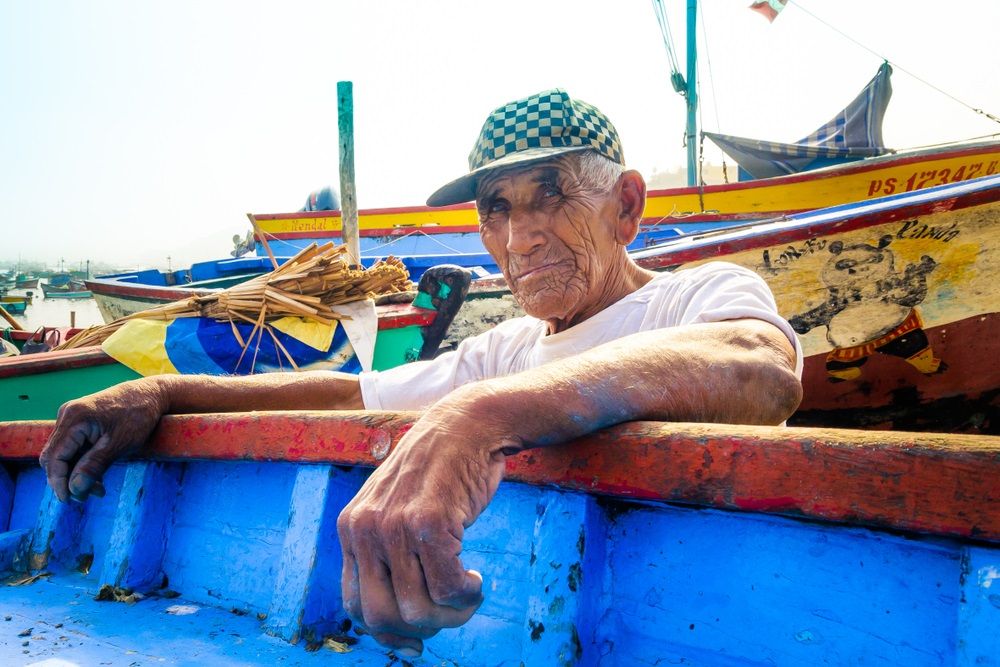 Peru kikötőjében egy halász áll.